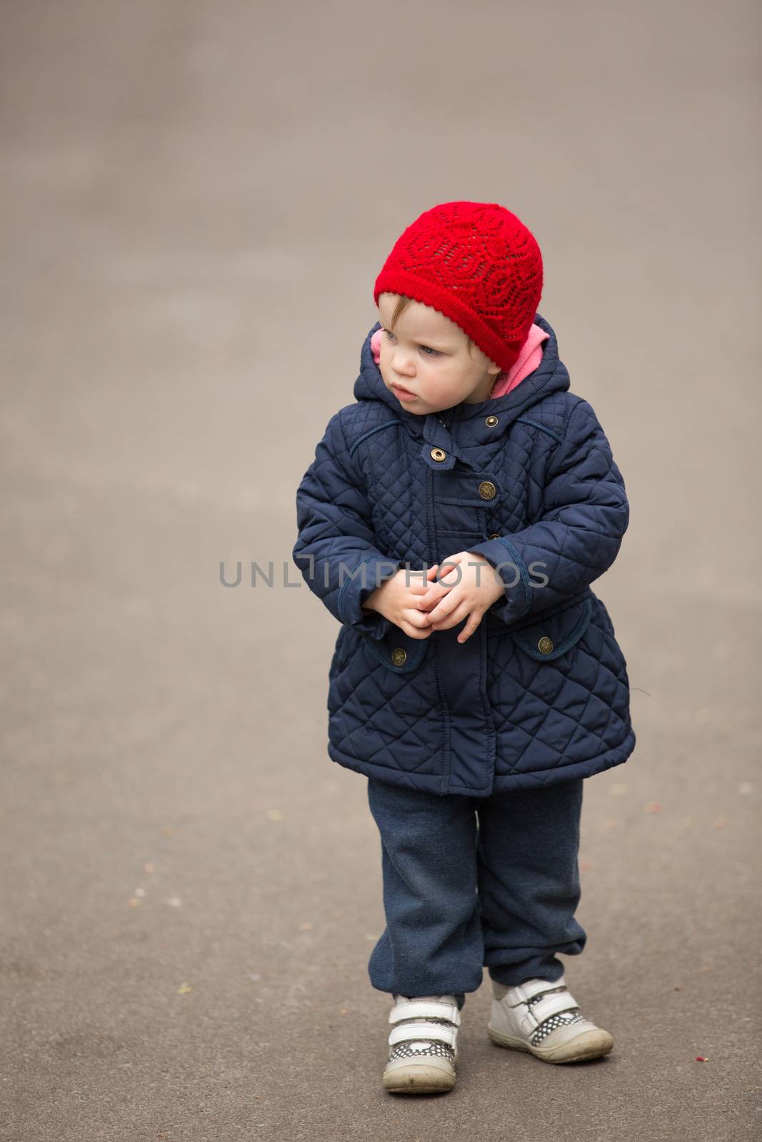 little girl on a park alley in spring