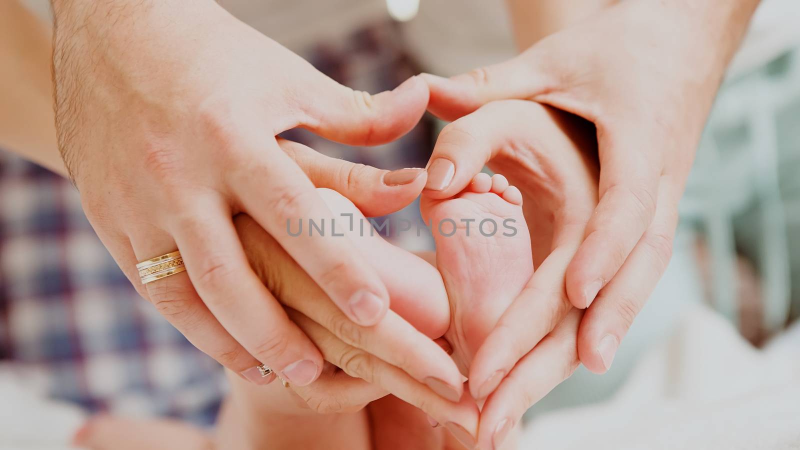 Children&amp;#39;s feet in hands of mother and father. by sarymsakov