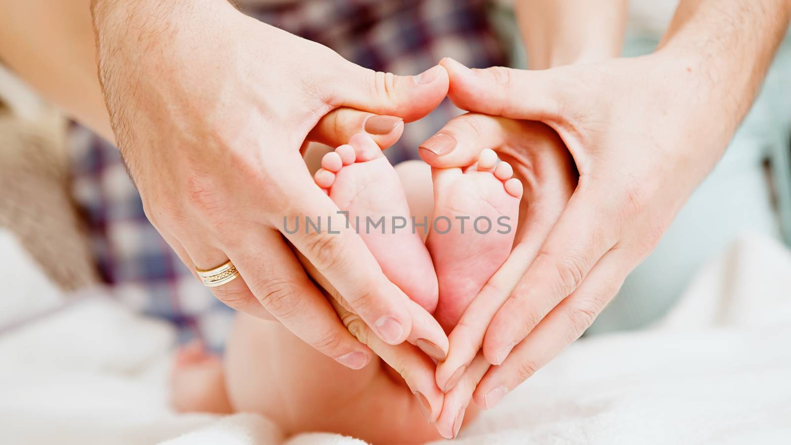 Children&amp;#39;s feet in hands of mother and father. by sarymsakov