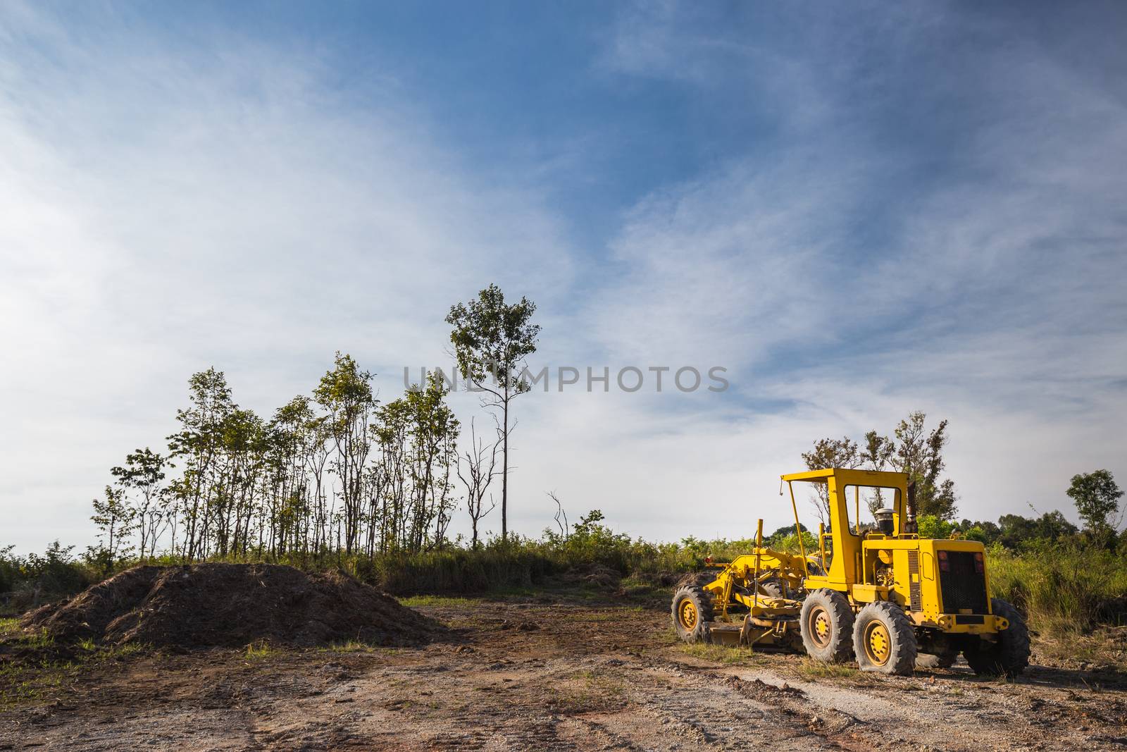 Wheel loader Excavator in the field with clear bule sky and tree in the background