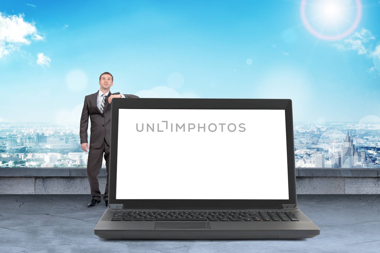 Businessman standing with big laptop by cherezoff