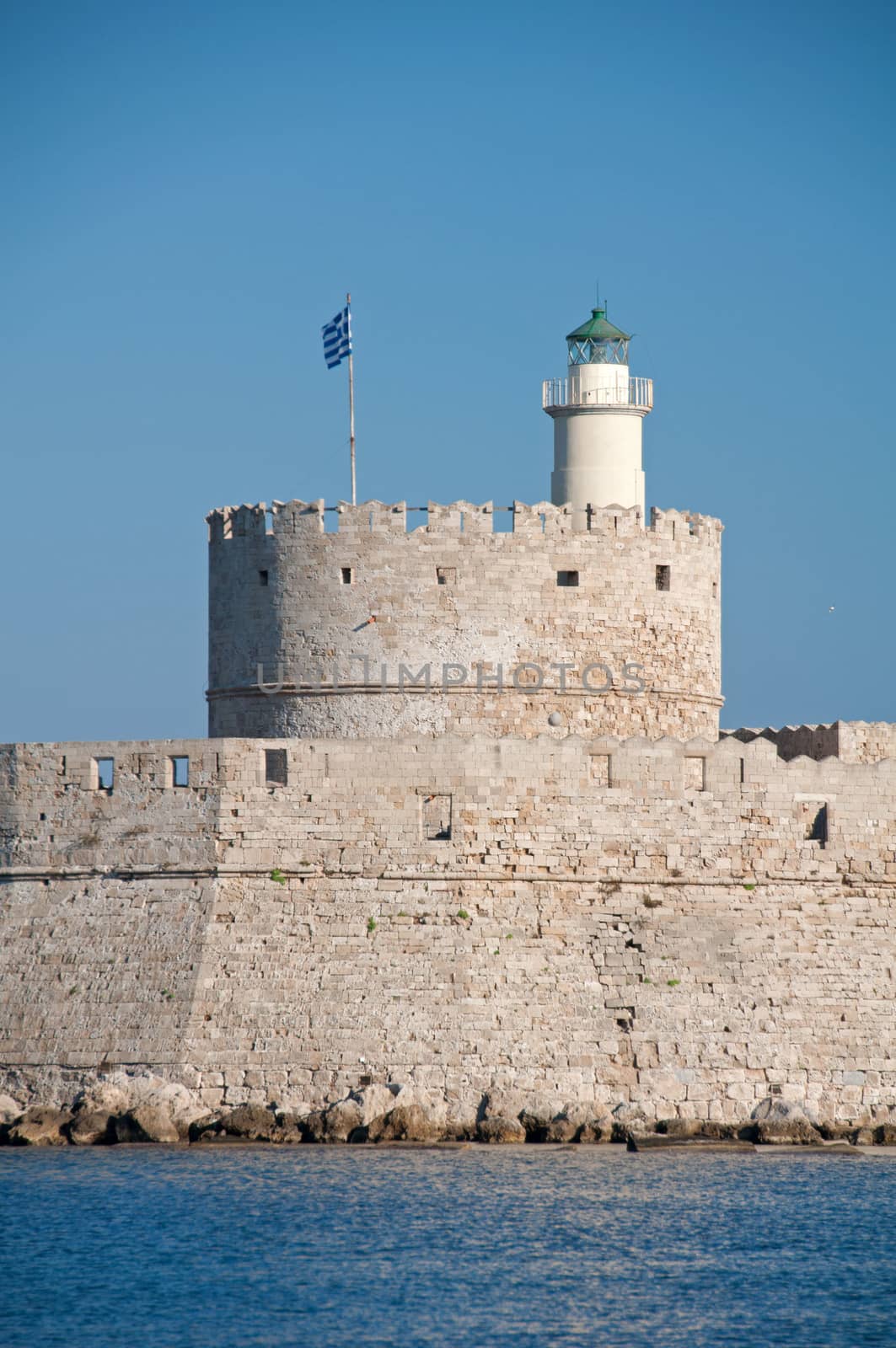 St. Nicholas fortress guards the mouth of Mandraki Harbour on the greek island of Rhodes. The fort, now a lighthouse, stands at the site of the legendary Colossus of Rhodes.