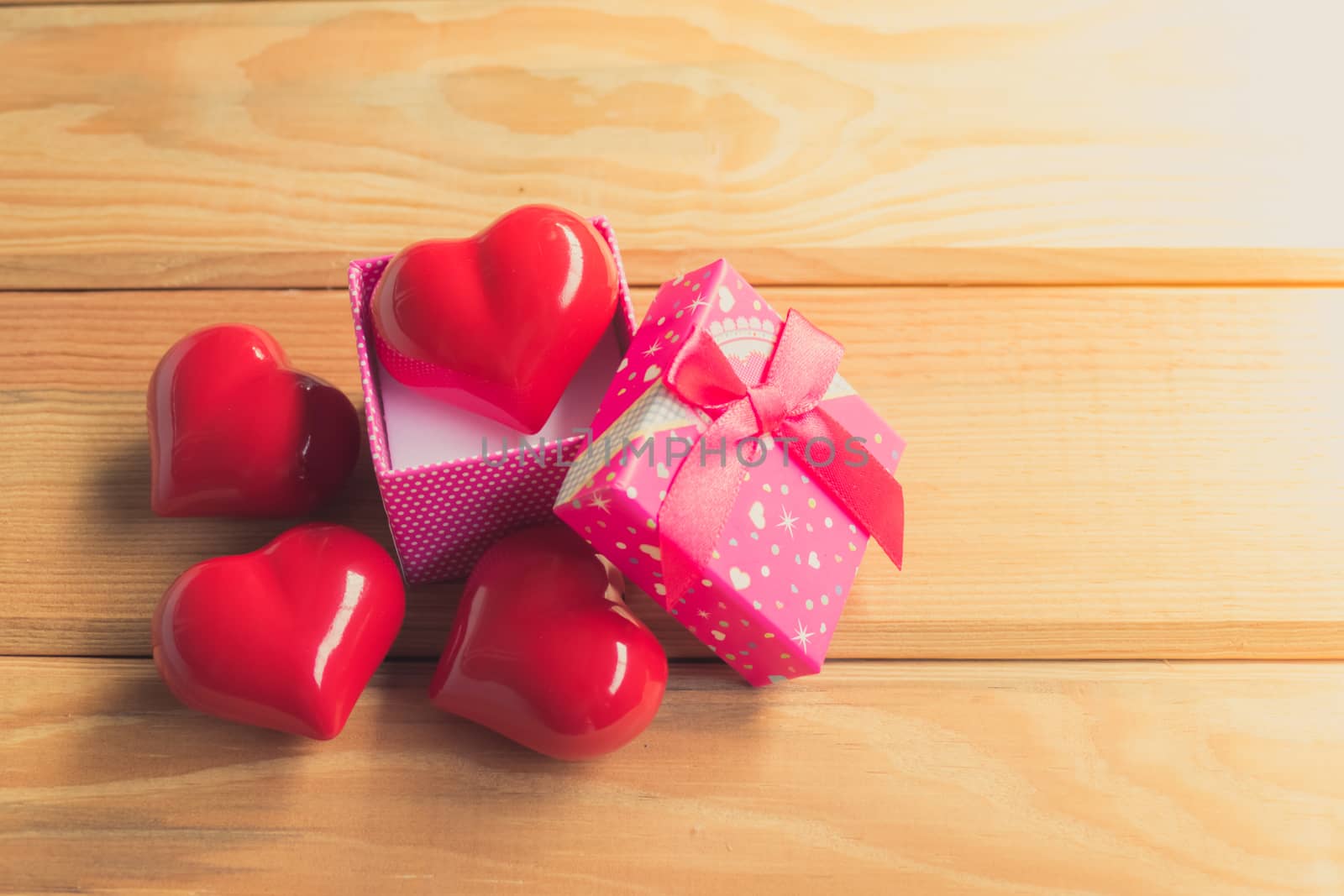 Gift of love. hearty gift. A gift box with a red heart inside. On the wooden floor