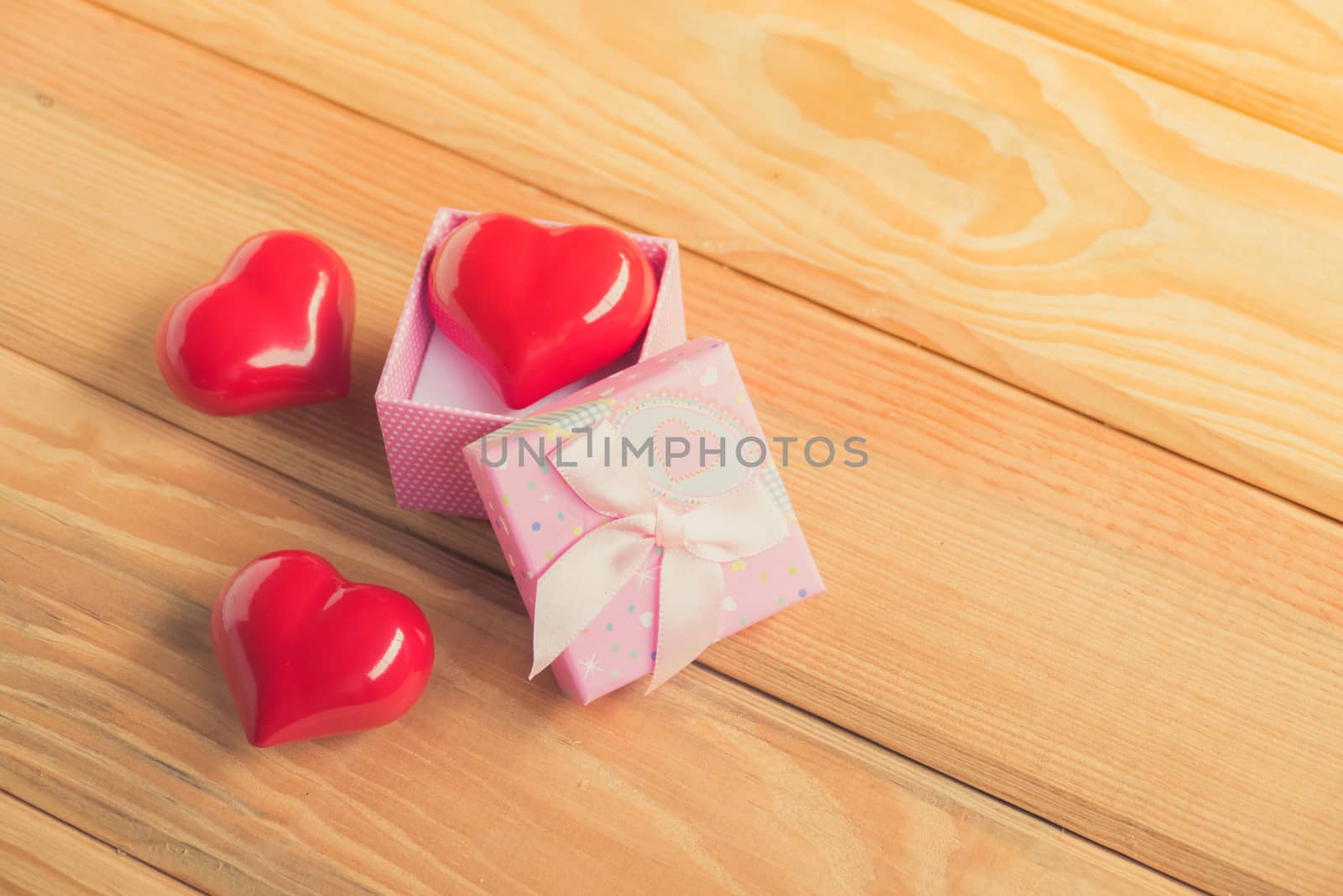 Gift of love. hearty gift. A gift box with a red heart inside. On the wooden floor