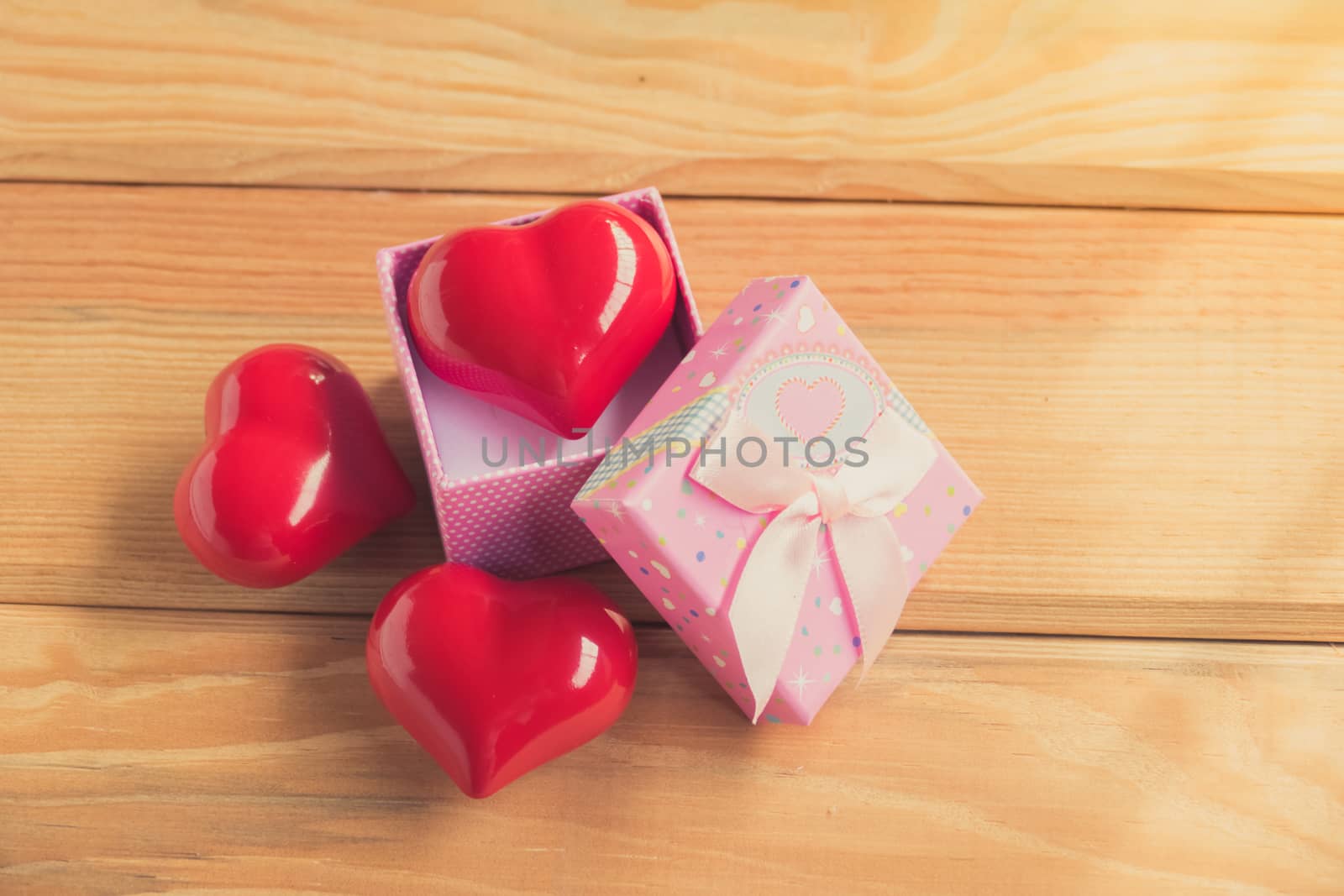 Gift of love. hearty gift. A gift box with a red heart inside. On the wooden floor