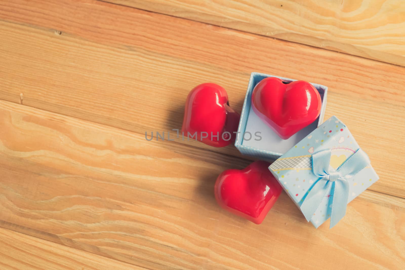 Gift of love. hearty gift. A gift box with a red heart inside. On the wooden floor