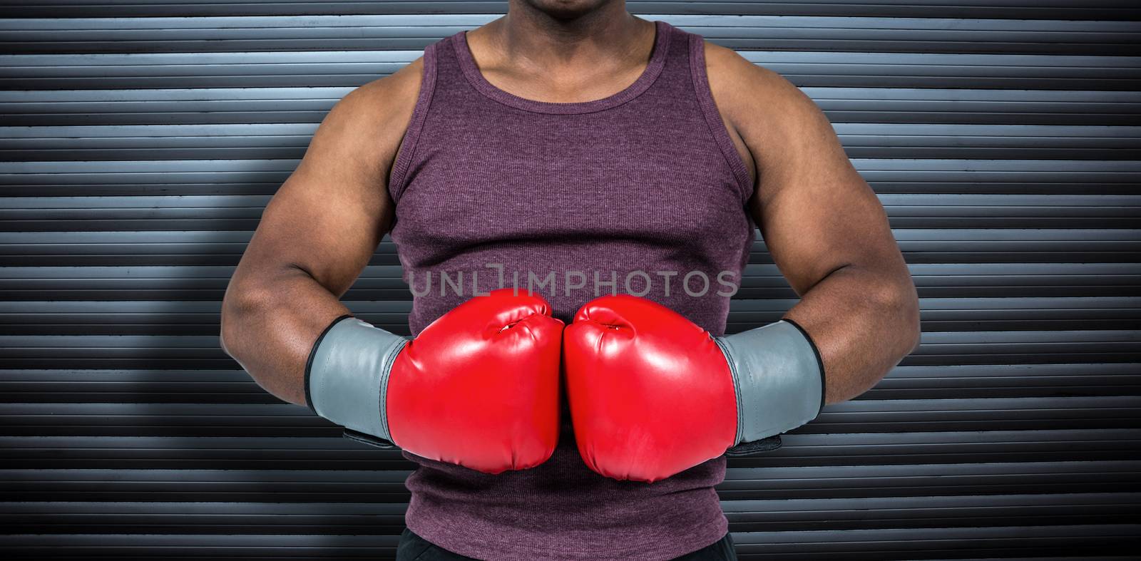 Fit man with boxing gloves  against grey shutters