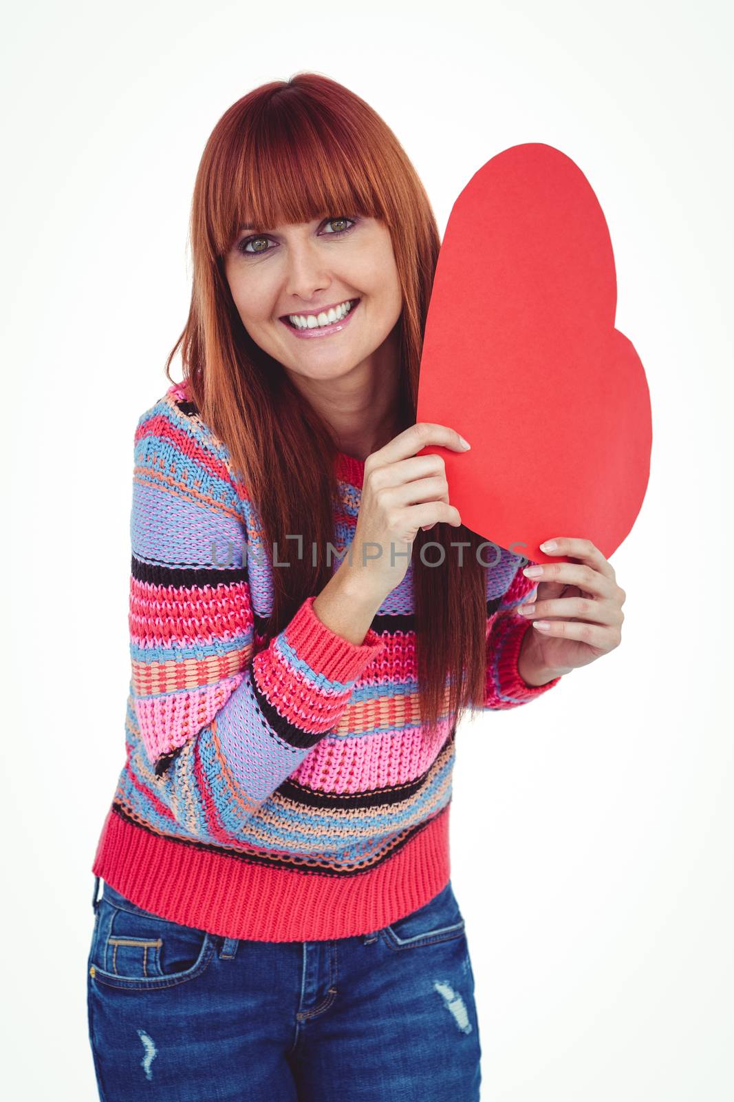 Smiling hipster woman holding a red heart against white background