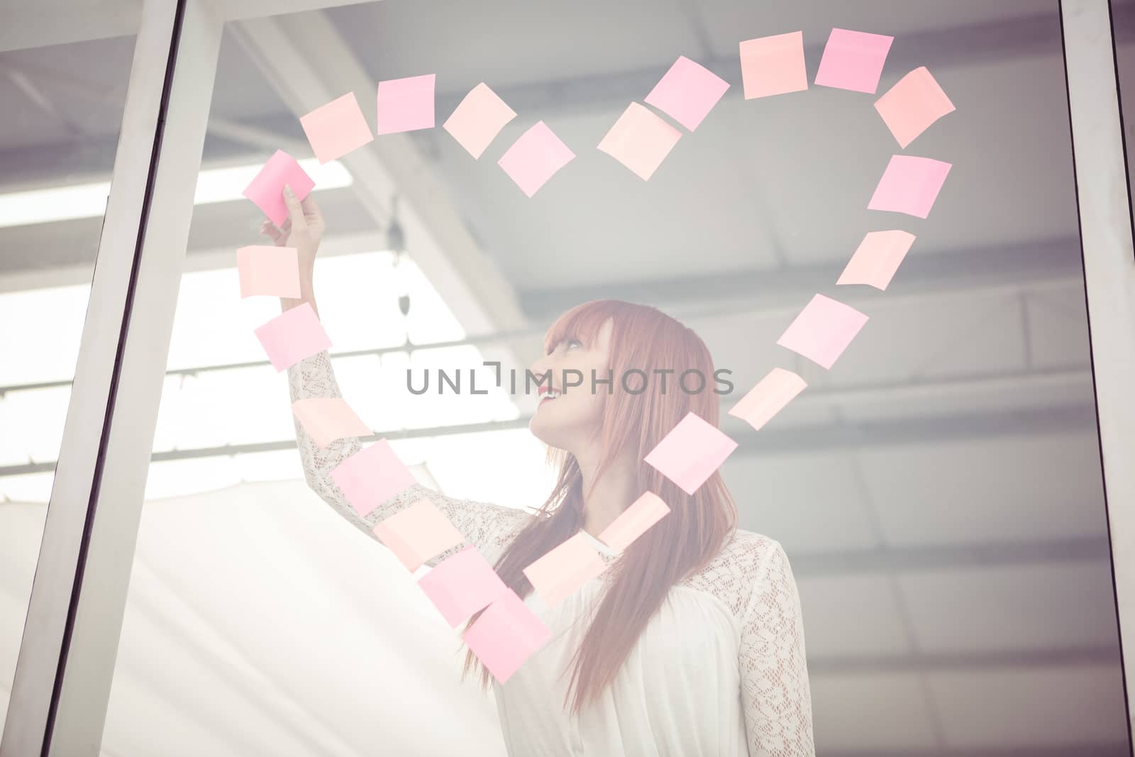Smiling hipster woman doing a heart in post-it by Wavebreakmedia