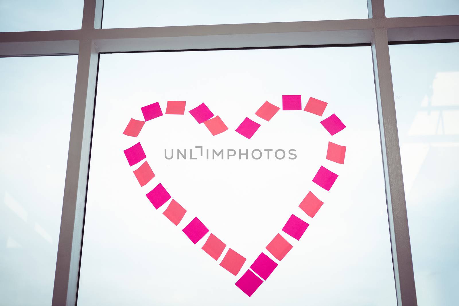 Heart in post-it on a window in office