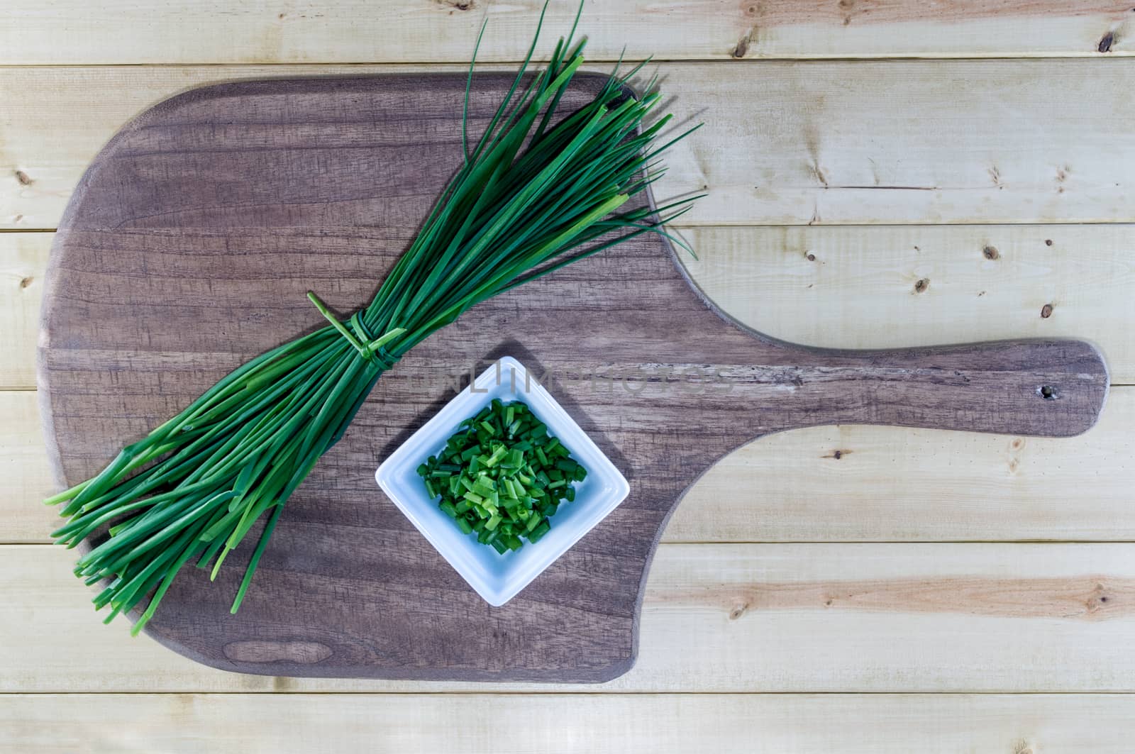 Fresh chives on rustic wooden board