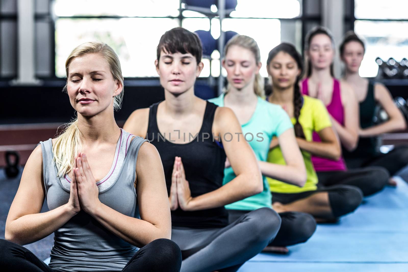 Fitness class doing yoga exercises in the gym