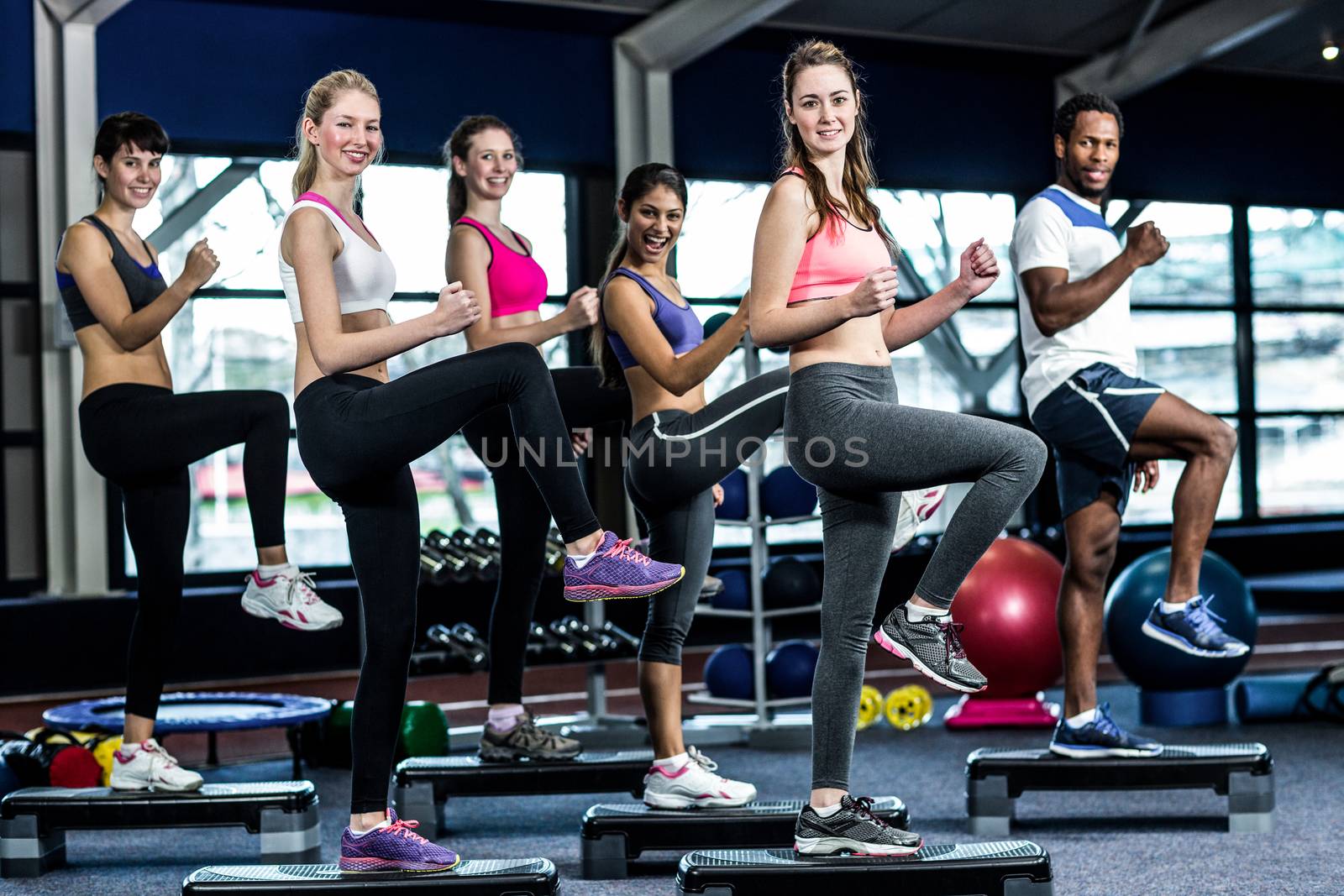 Fit smiling group doing exercise in gym