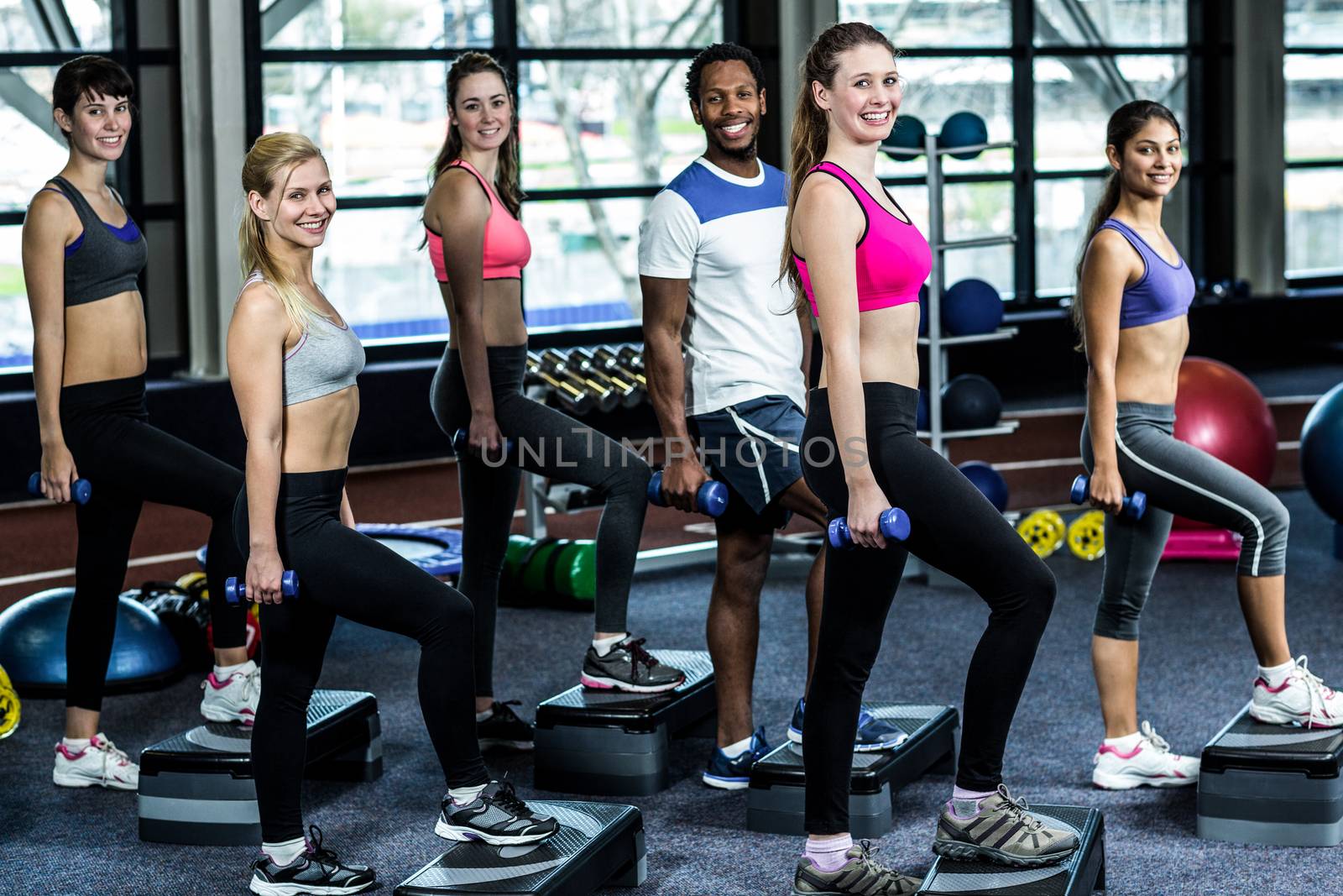 Fit smiling group doing exercise in gym