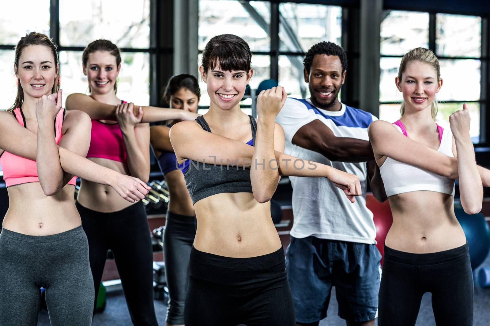 Fit smiling group doing exercise in gym