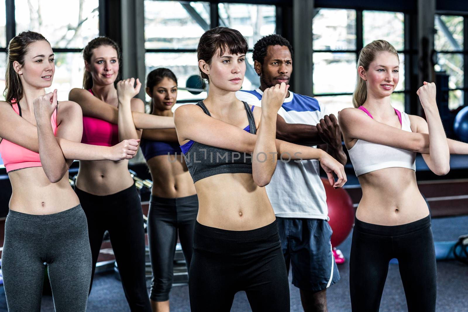 Fit smiling group doing exercise in gym