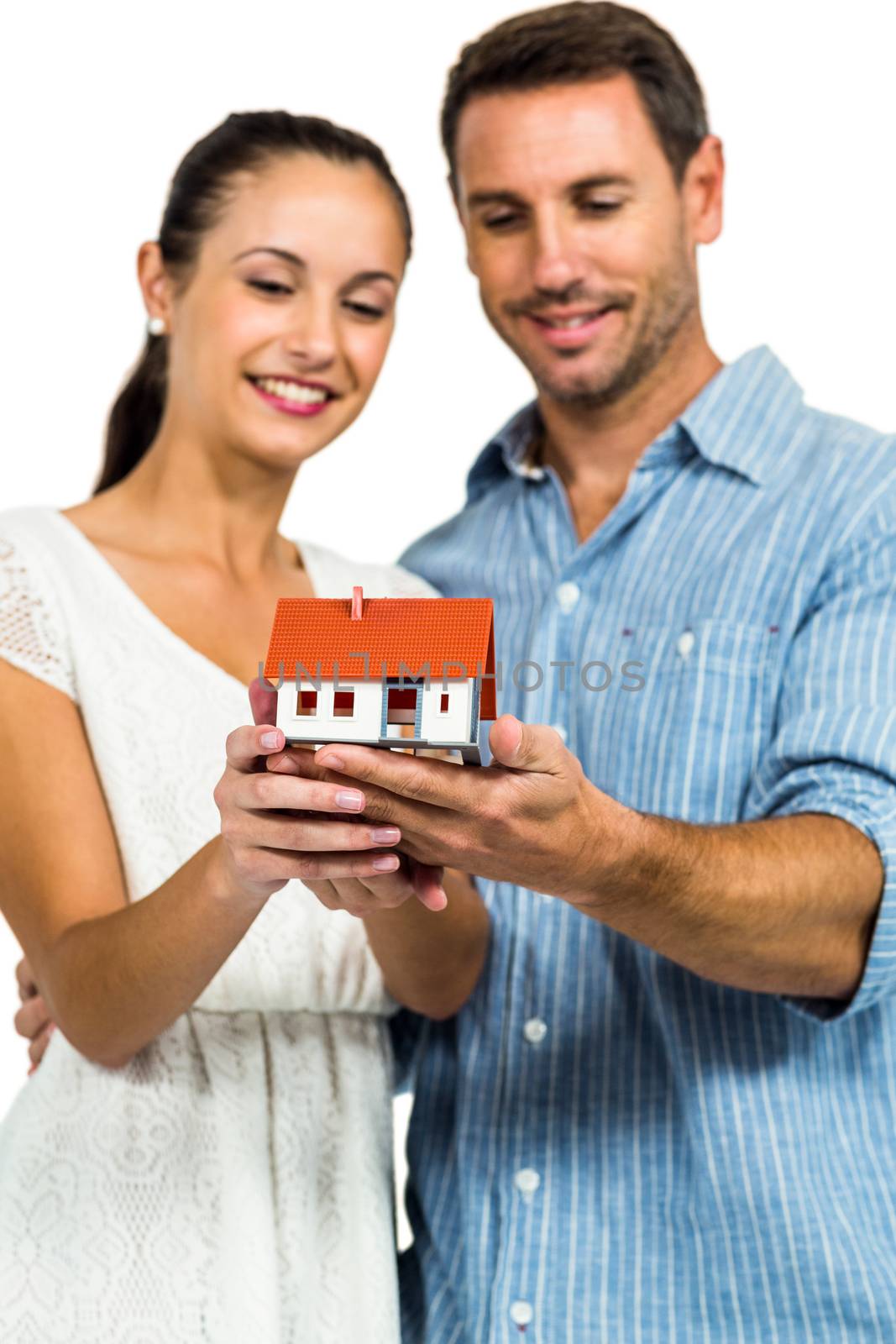 Young couple holding house model on white screen