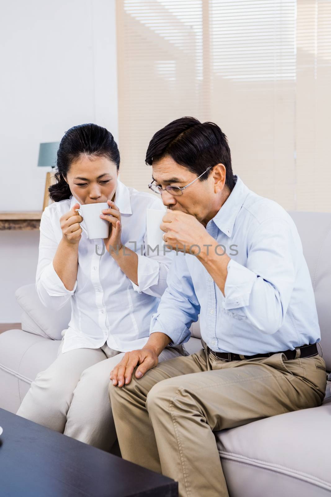 Couple enjoying drinks on the couch at home