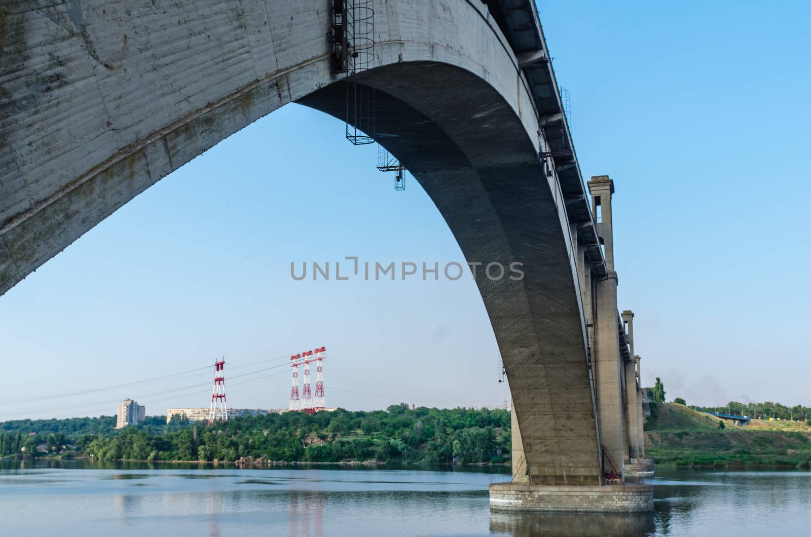 road and rail split-level bridge over the river on a background of blue sky in the city with the train