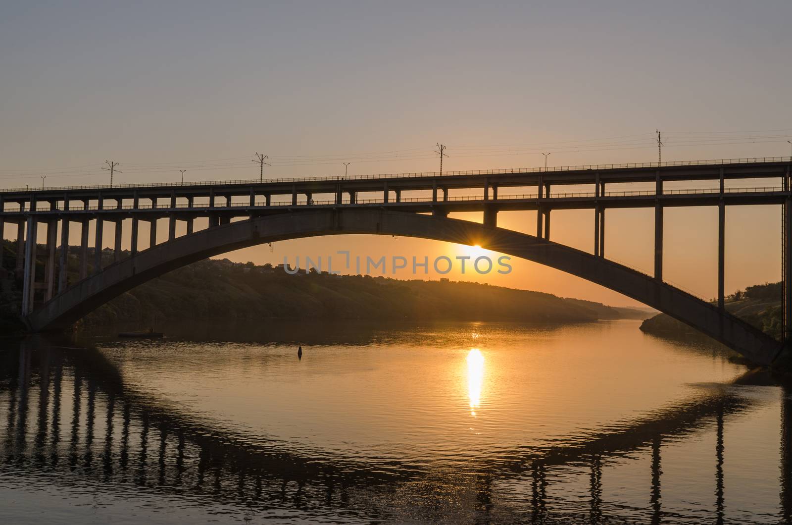 road and rail split-level bridge over the river on a background of blue sky in the city