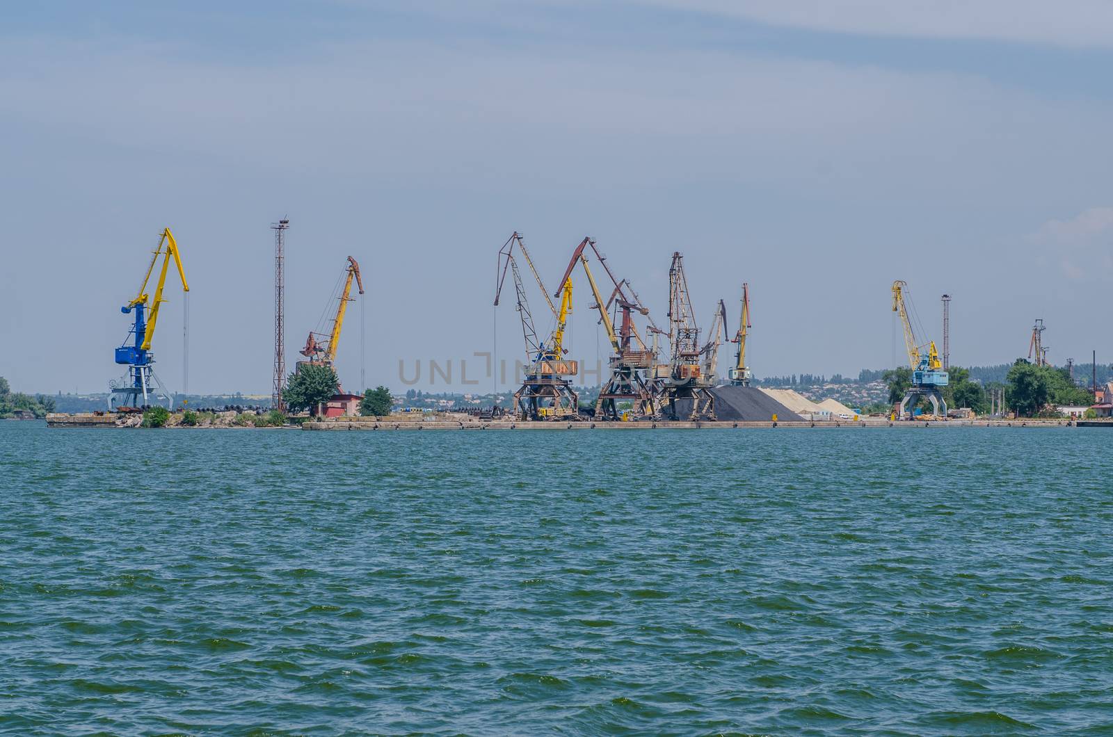 cargo port with cargo cranes on a blue sky background