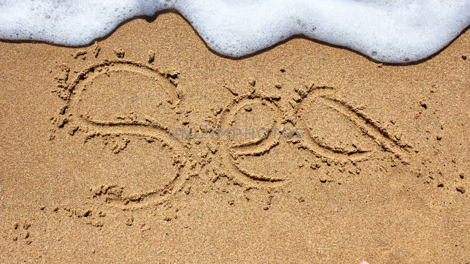 Sea word written on the beach sand.