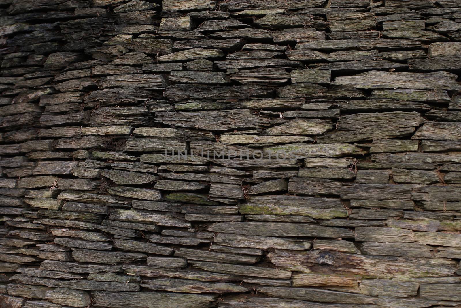 Stone wall made of dark gray stones 