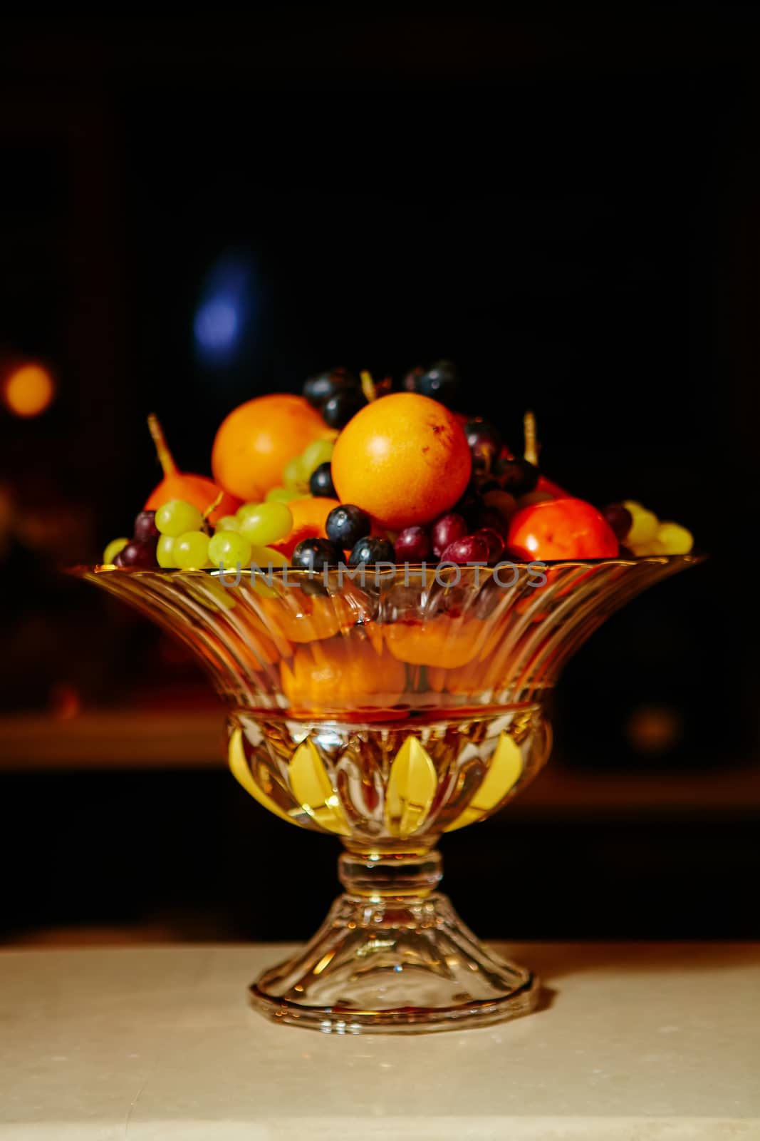 Assortment of juicy fruits on wooden table, on black background