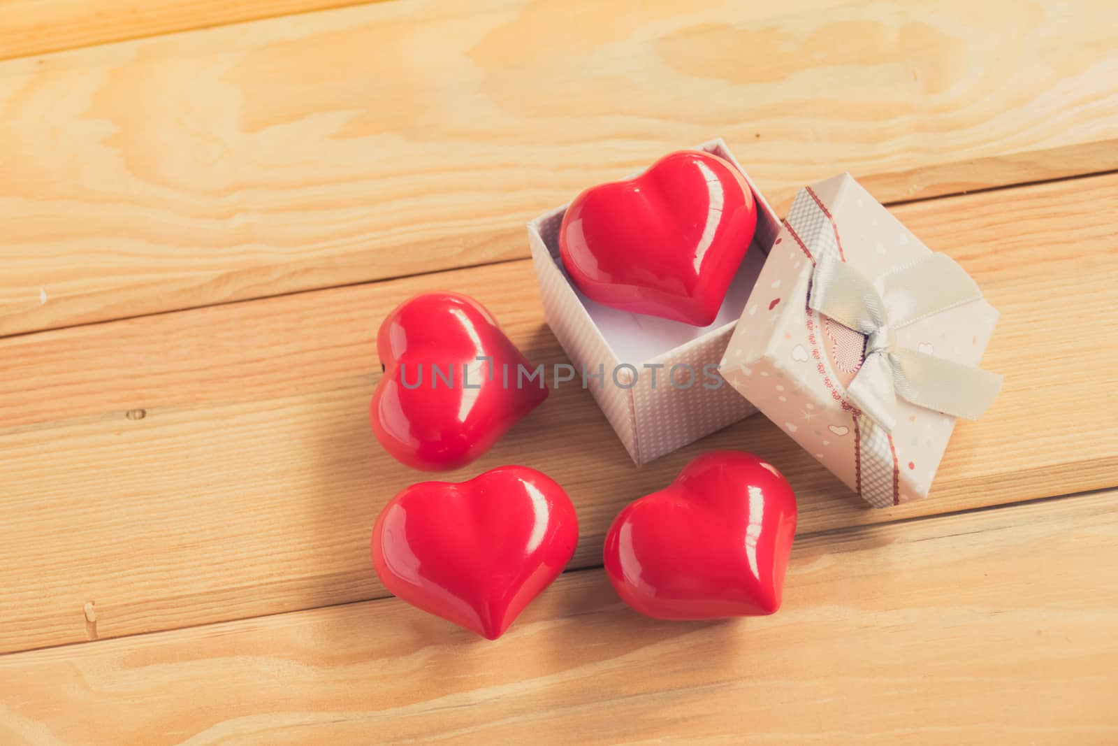 Gift of love. hearty gift. A gift box with a red heart inside. On the wooden floor