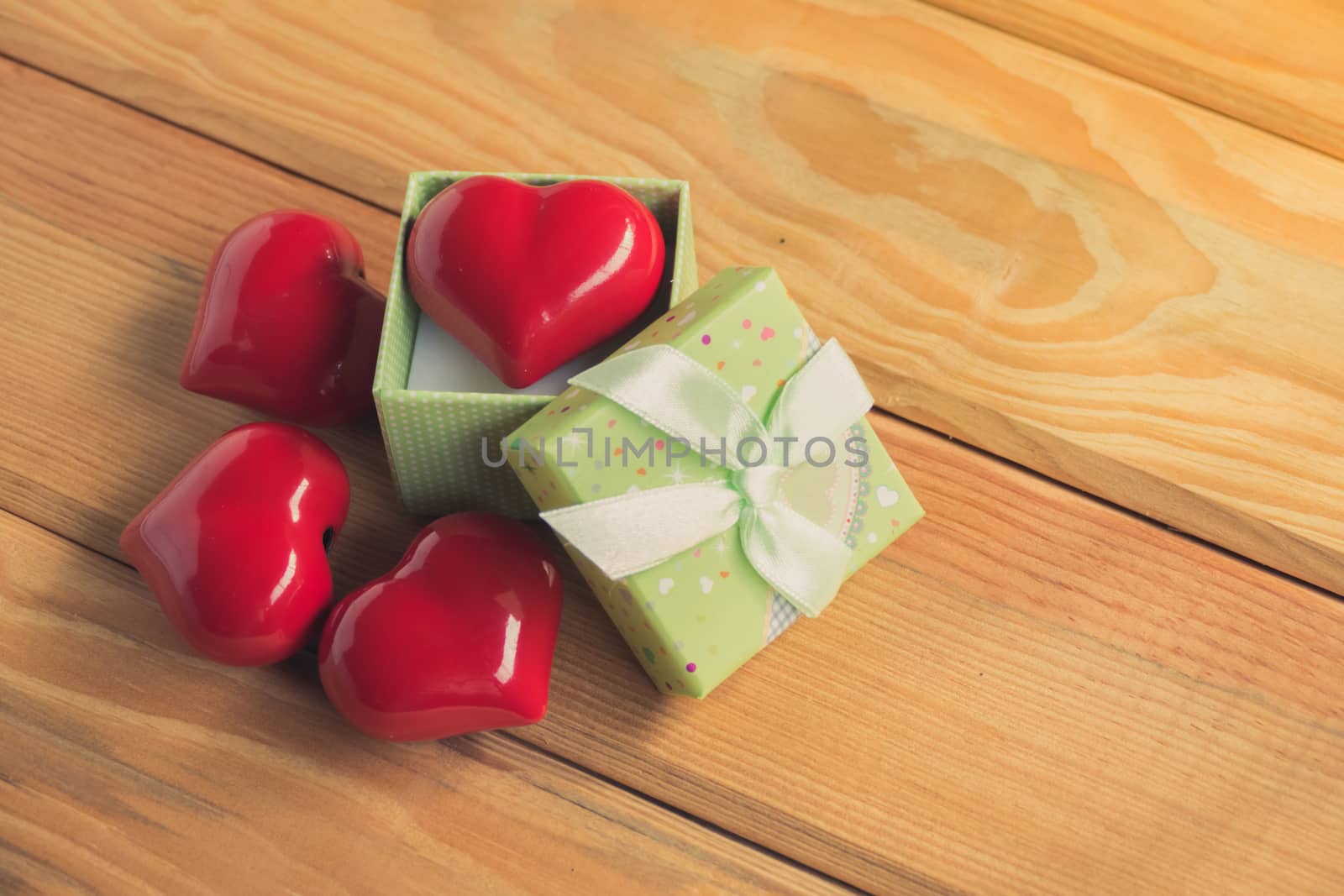 Gift of love. hearty gift. A gift box with a red heart inside. On the wooden floor