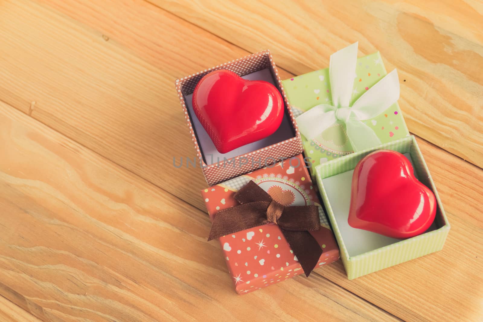 Gift of love. hearty gift. A gift box with a red heart inside. On the wooden floor