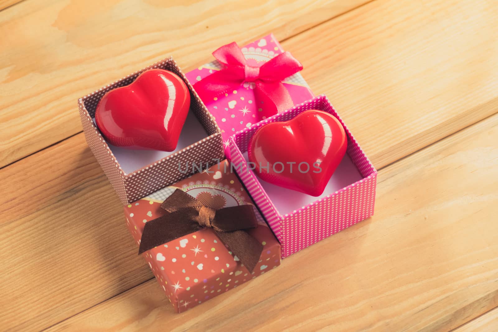 Gift of love. hearty gift. A gift box with a red heart inside. On the wooden floor