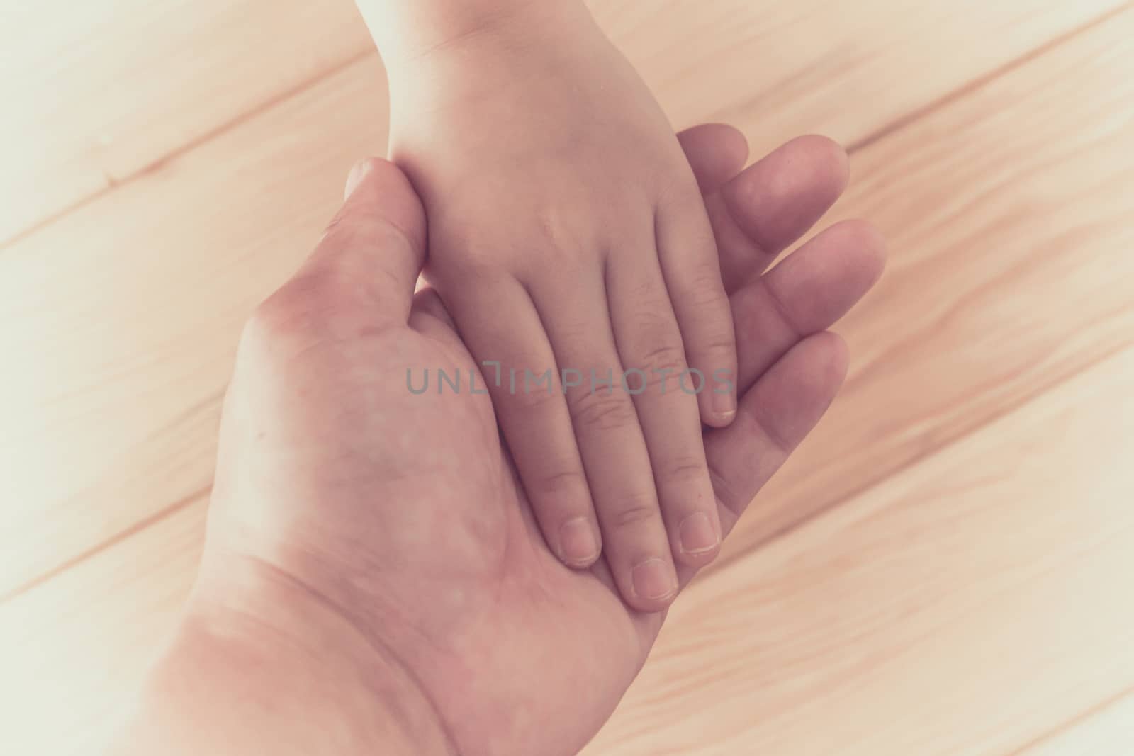 Hands clasped together on wood background, art background