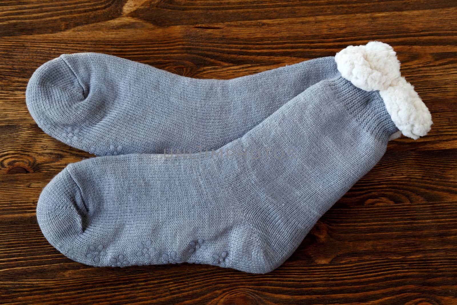 grey knitted socks with fur lining on a wooden surface