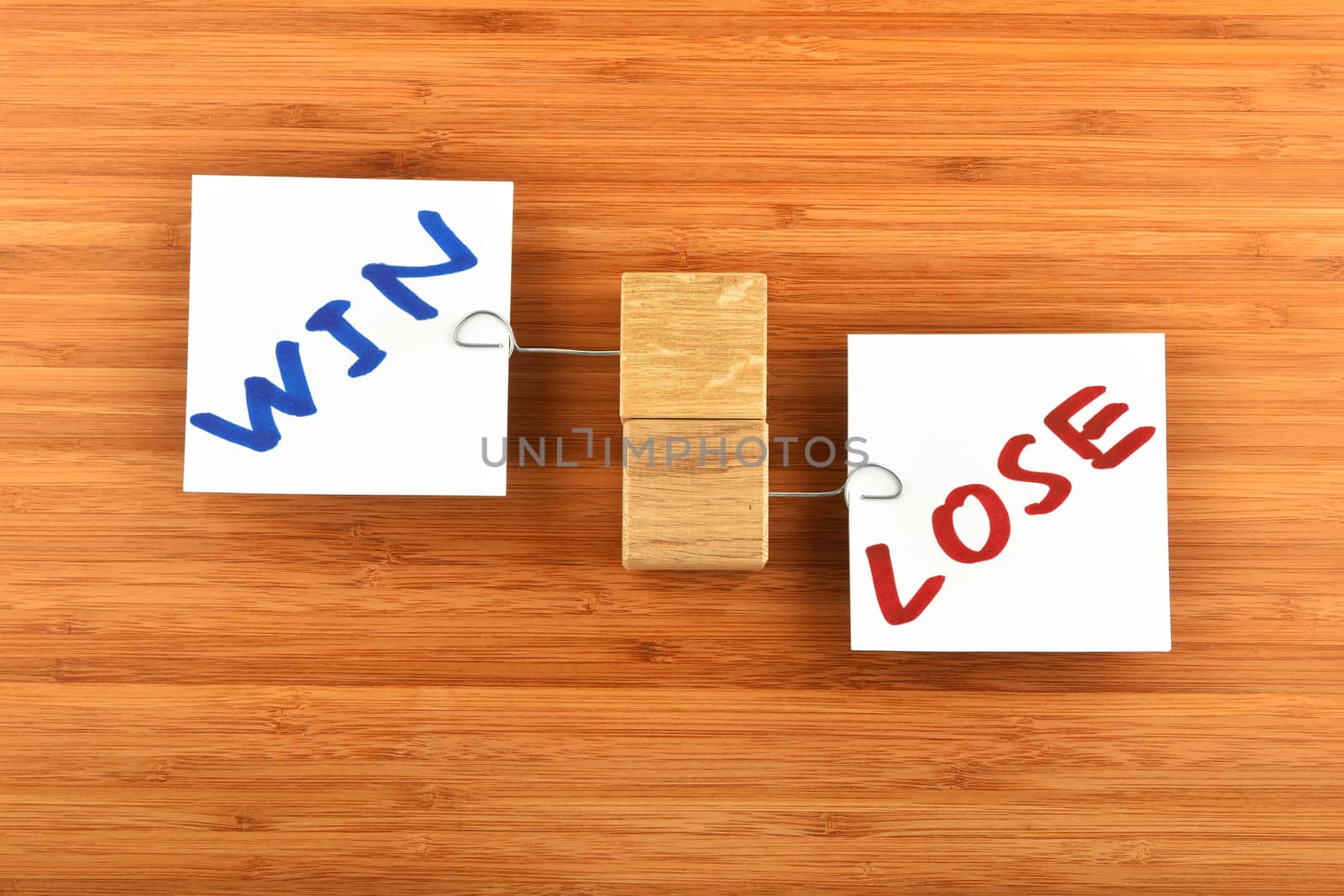 win lose, two white paper notes with wooden holders in different directions on wooden bamboo background for presentation