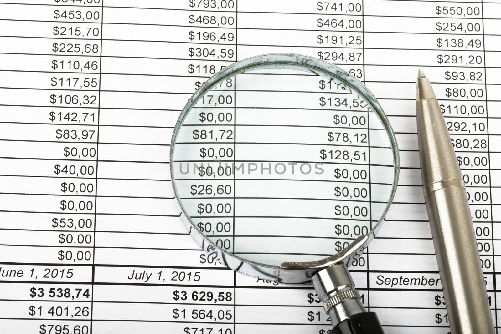 Magnifier and pen on bills background, closeup