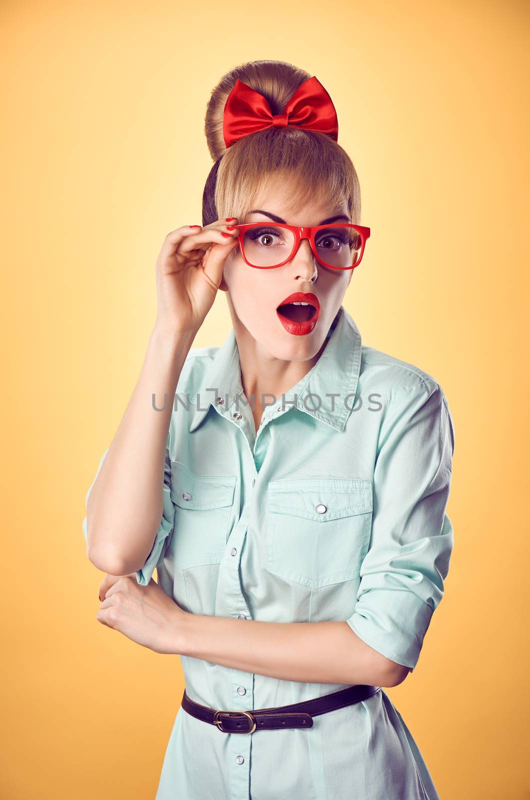 Beauty fashion portrait business woman, stylish red glasses surprised, open mouth, shocked. Attractive blonde girl,  confidence, Pinup hairstyle bow makeup.Unusual playful, emotions.Vintage, on yellow