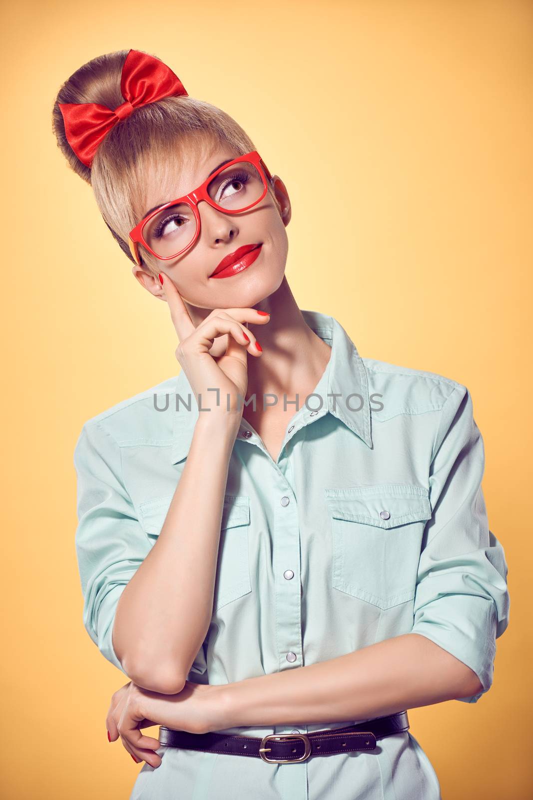 Beauty fashion portrait business woman in stylish red glasses thinking, idea. Attractive pretty blonde girl smiling. Confidence, Pinup hairstyle bow makeup.Unusual playful, emotions.Vintage, on yellow