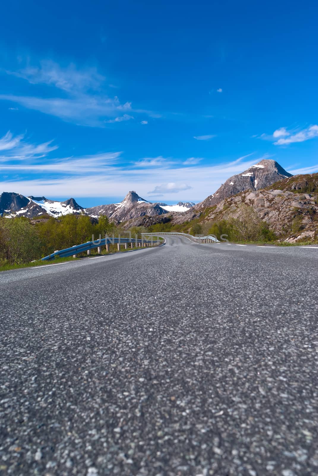 Asphalt road to Norvegian mountains in sunny clear day