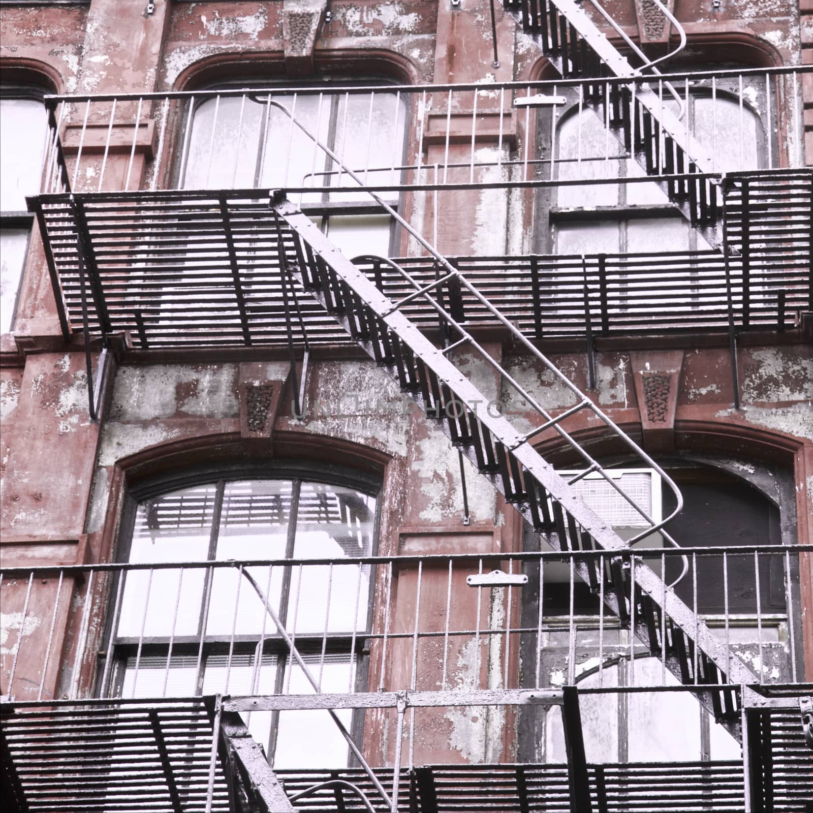 Weathered red  building with fire escape stairs in New York City, USA