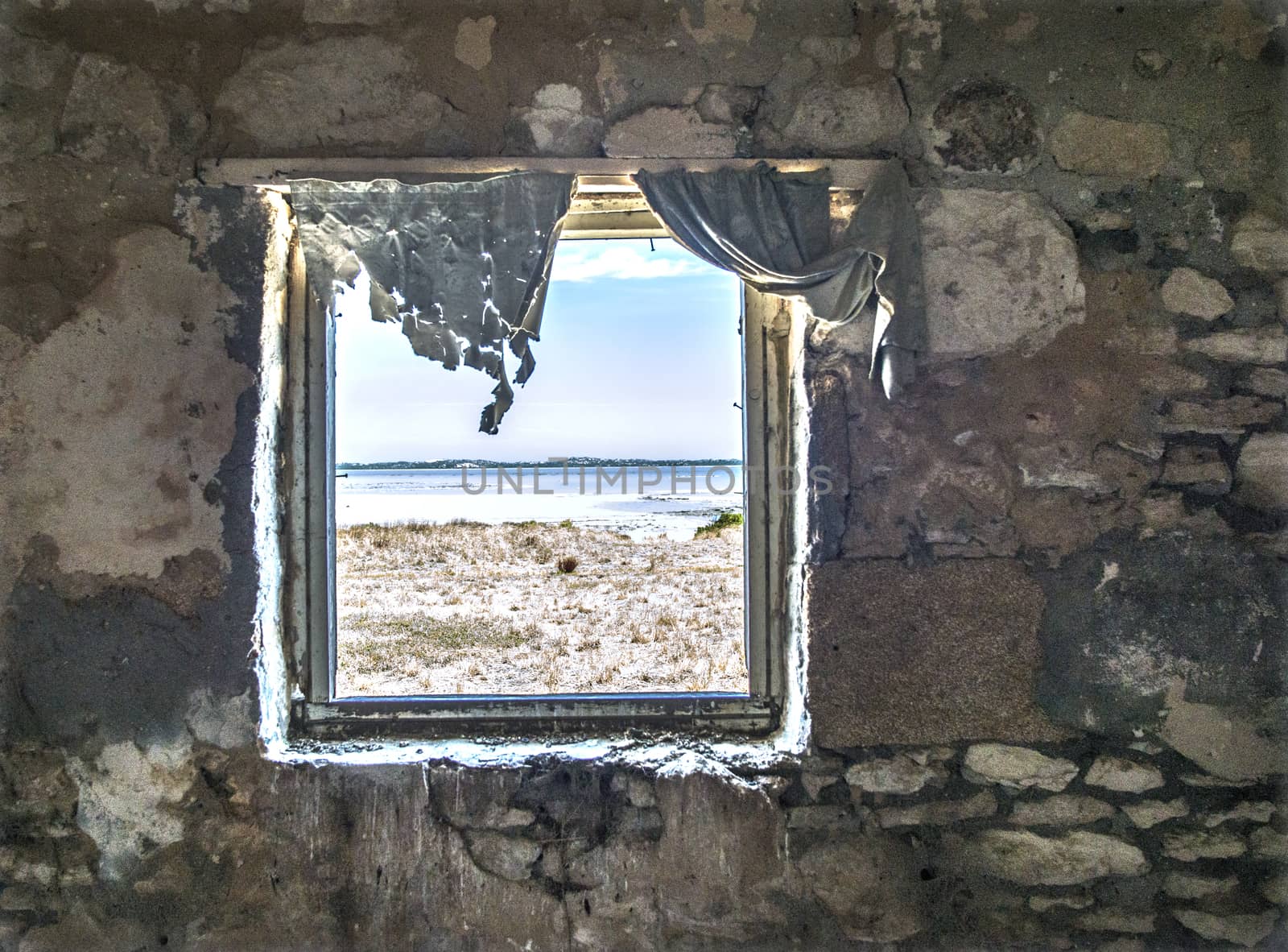 Looking through the window at beautiful coastal views from the ruins of an old stone building