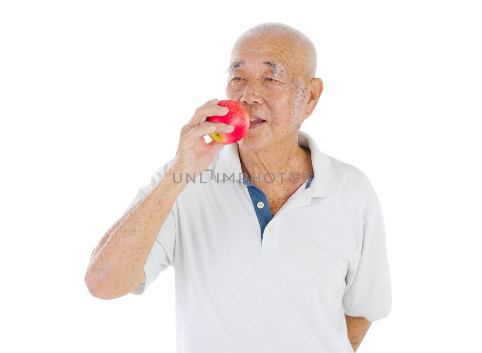 Portrait of a senior man about to eat a red apple