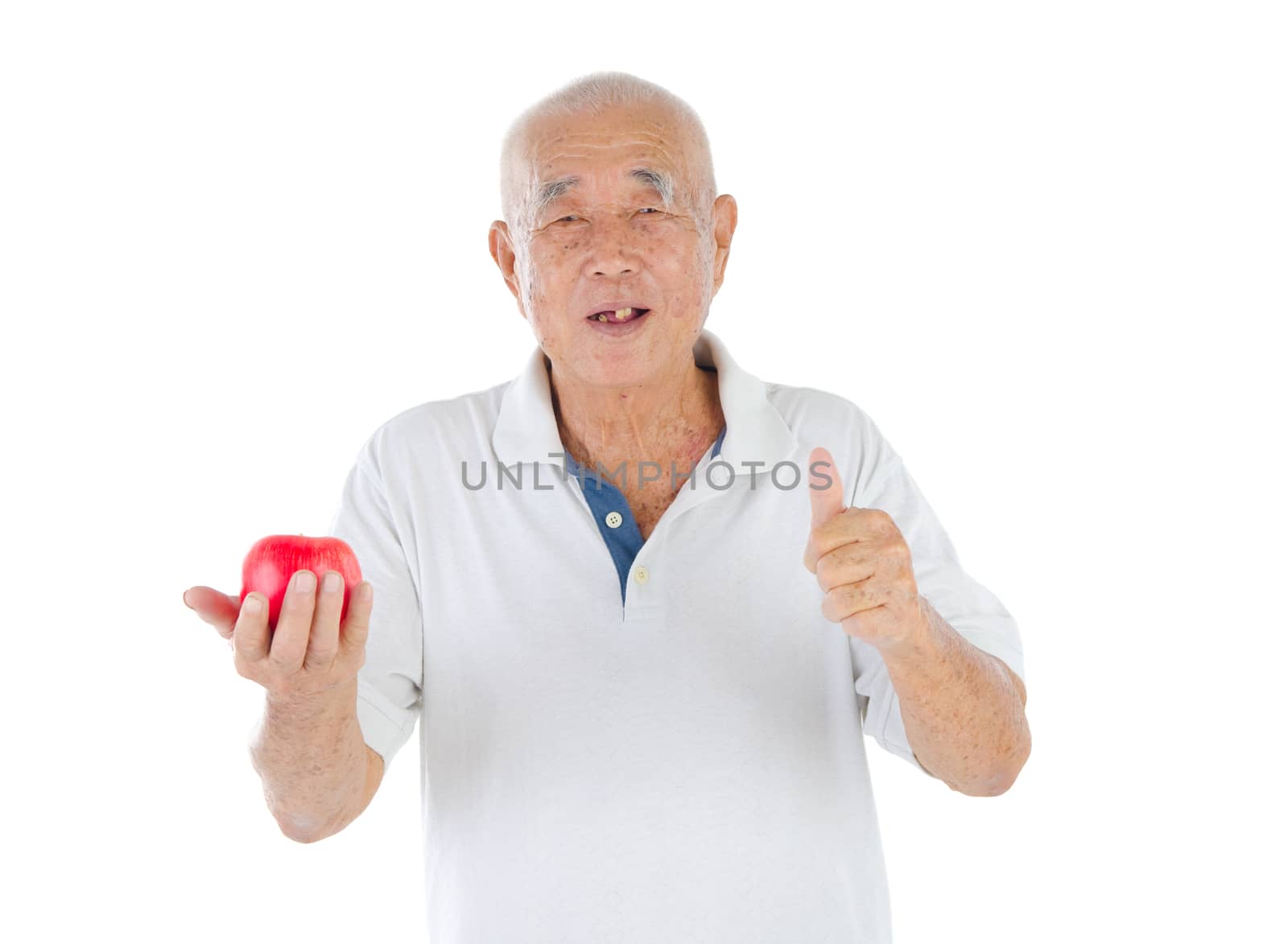 Closeup portrait senior man holding an apple, isolated on white background.