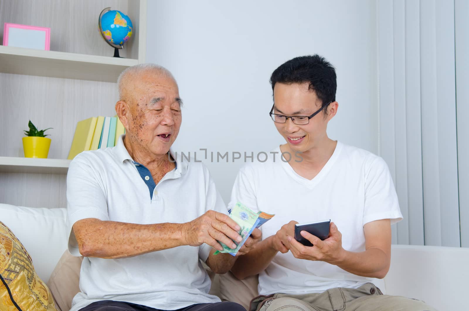 Asian senior man and son calculating money