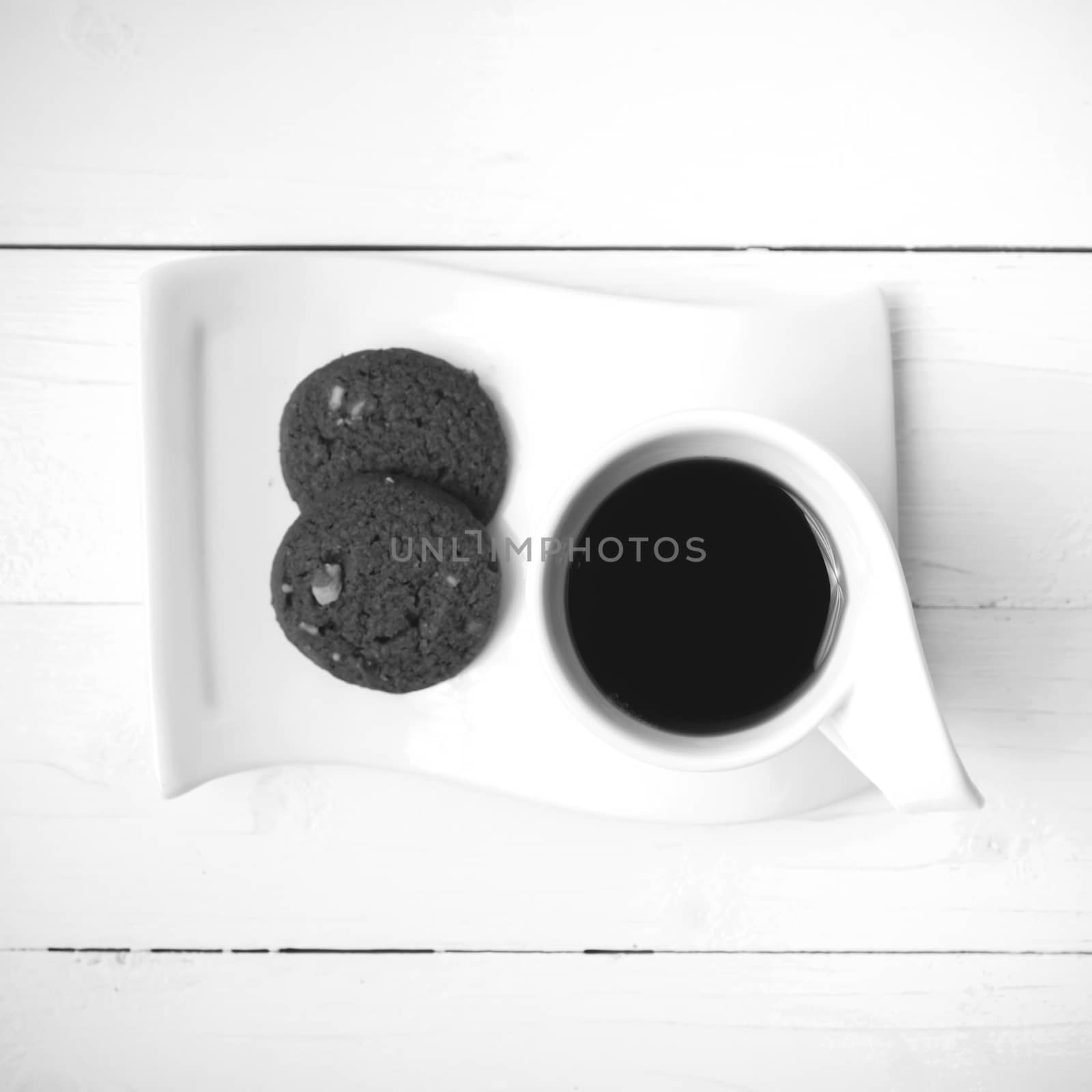 coffee cup with cookie on white wood background black and white color