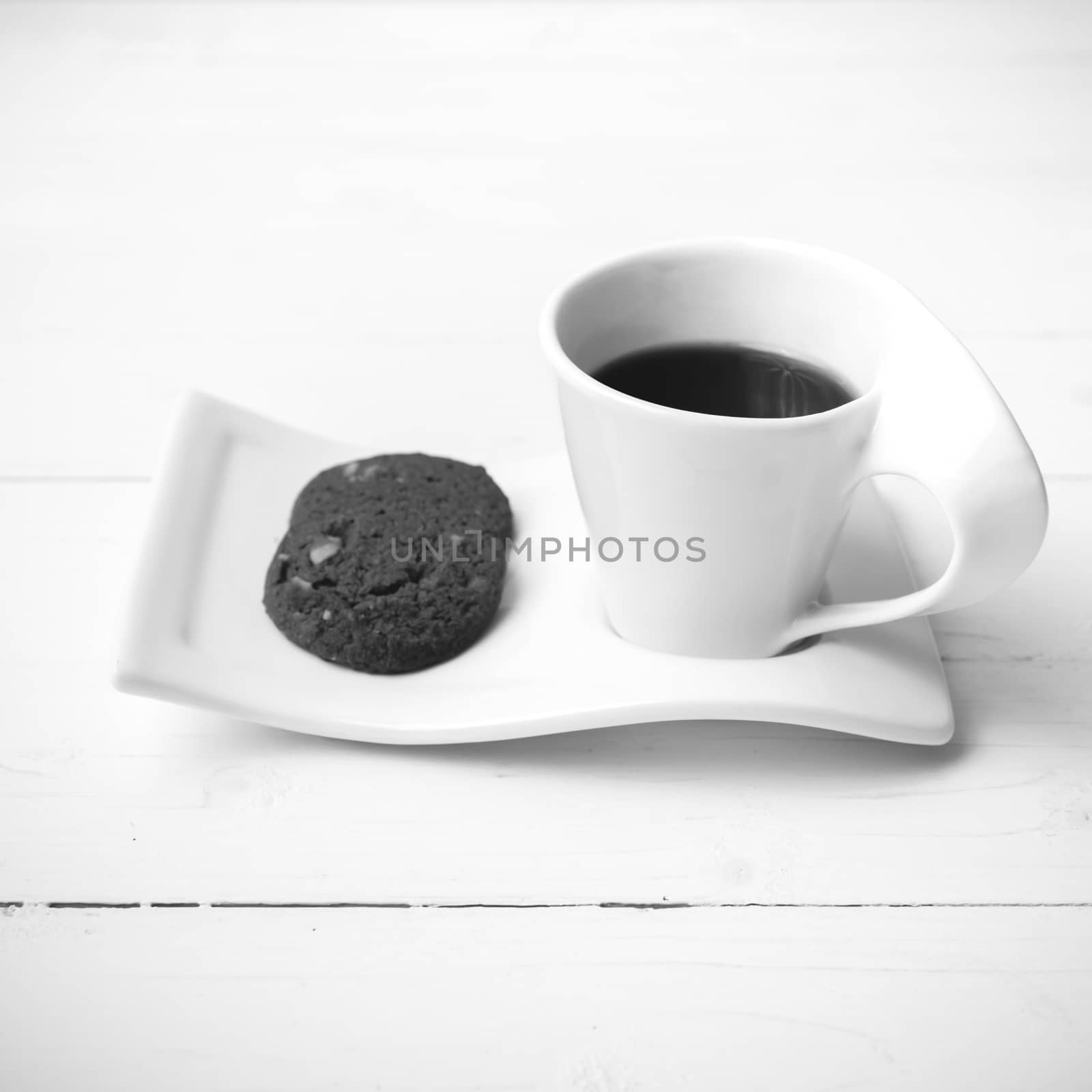 coffee cup with cookie on white wood background black and white color