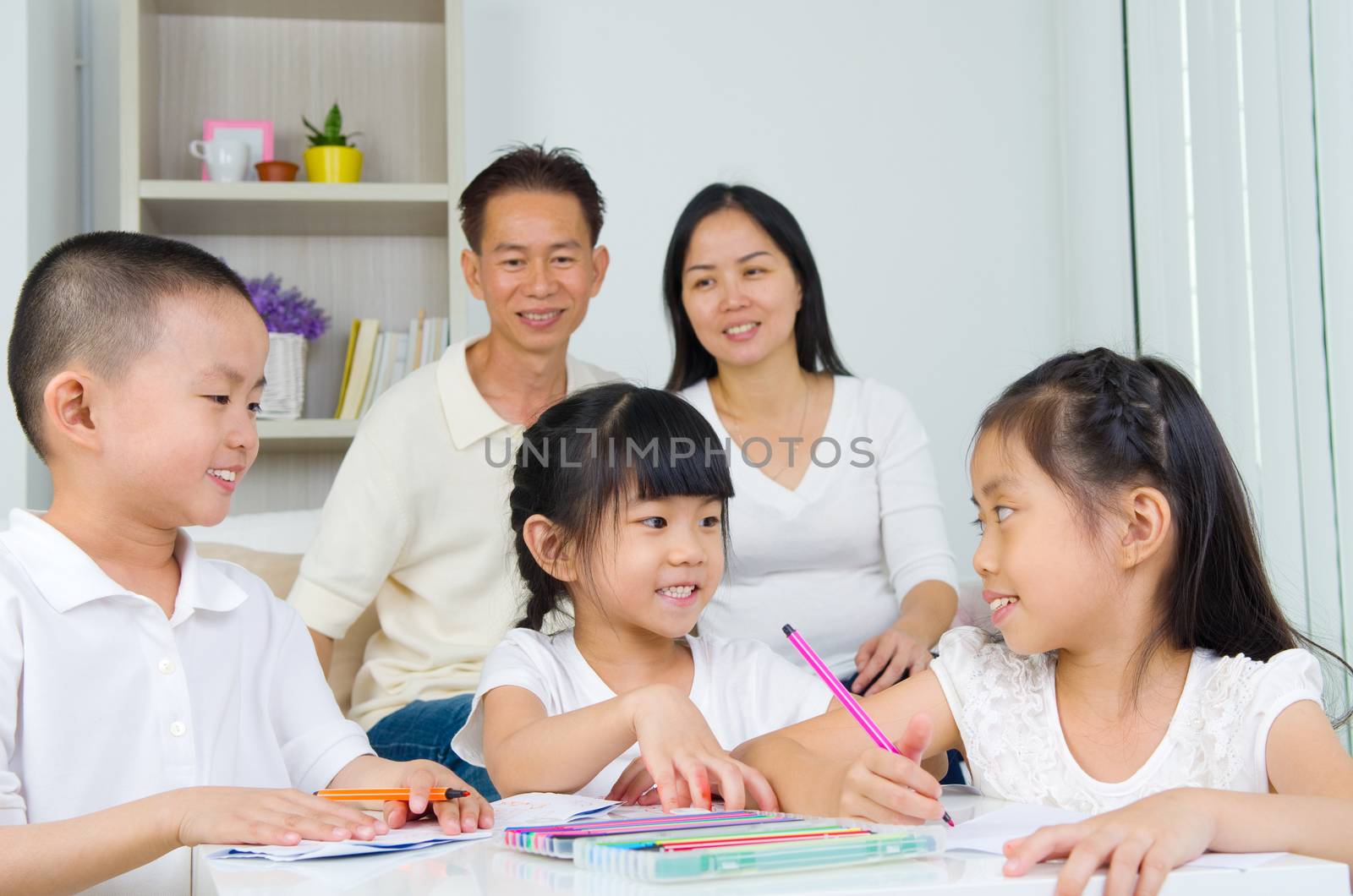 asian family doing school homework at living room