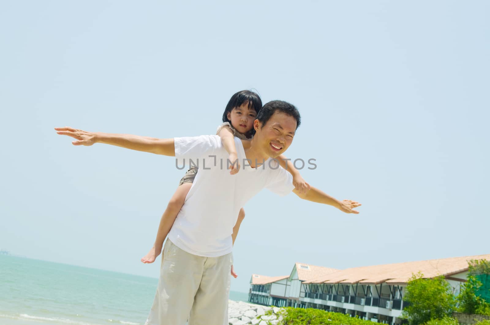 Happy father holding her daughter on the beach