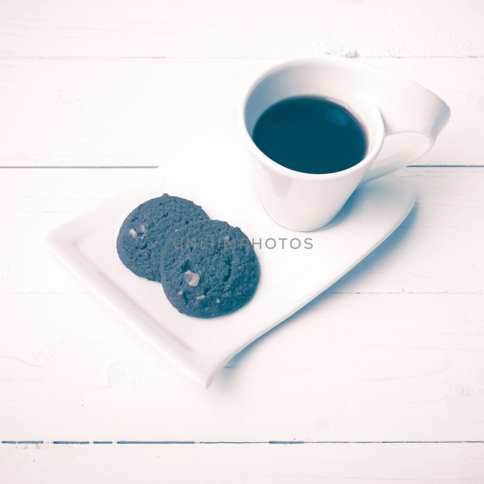 coffee cup with cookie on white wood background vintage style