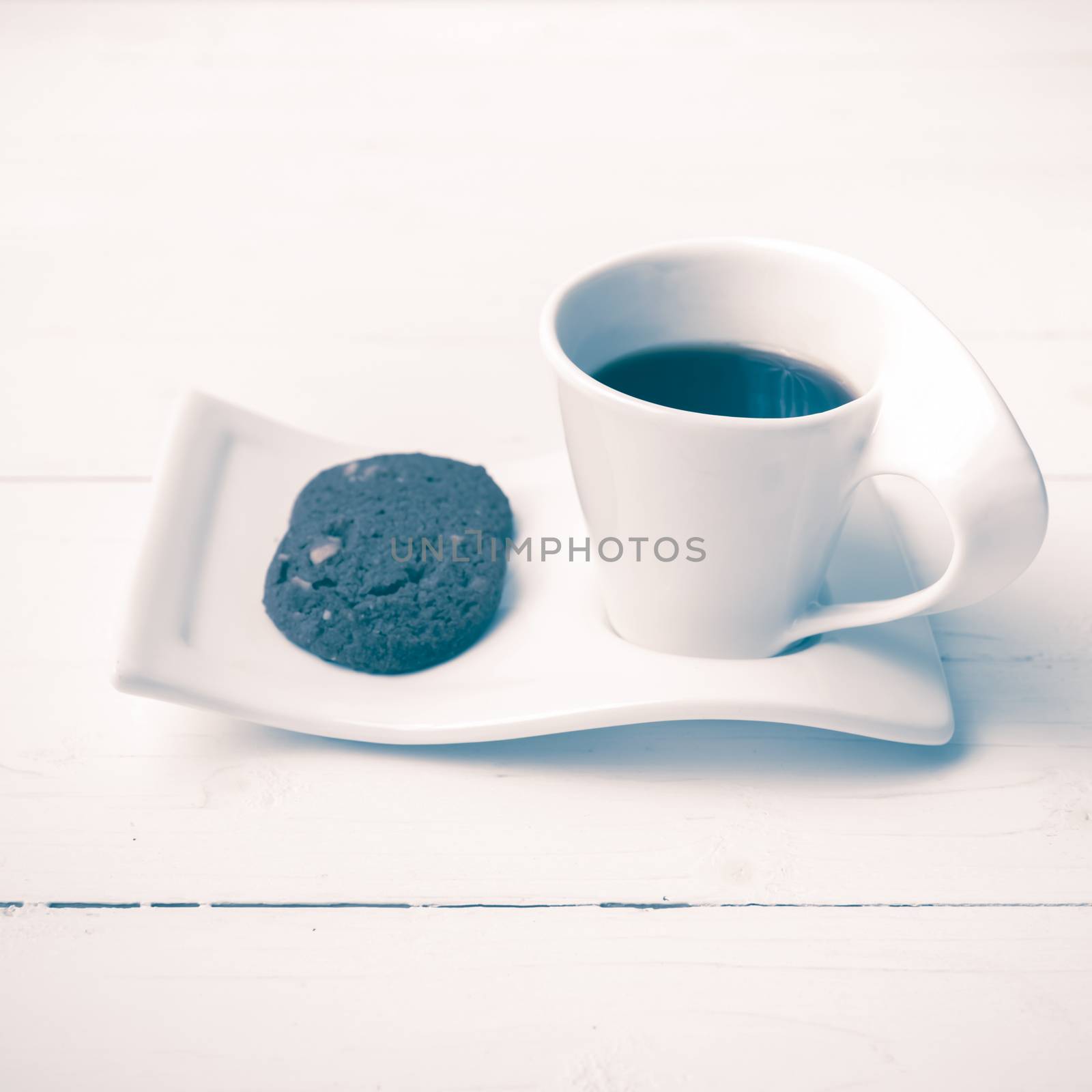 coffee cup with cookie on white wood background vintage style